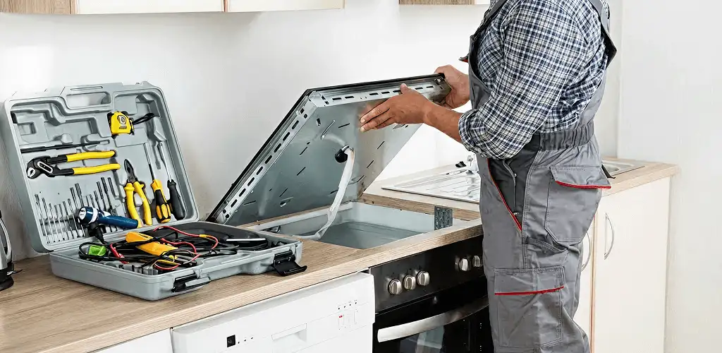 Handyman repairing a cooktop and checking wiring connections in Stockton, CA