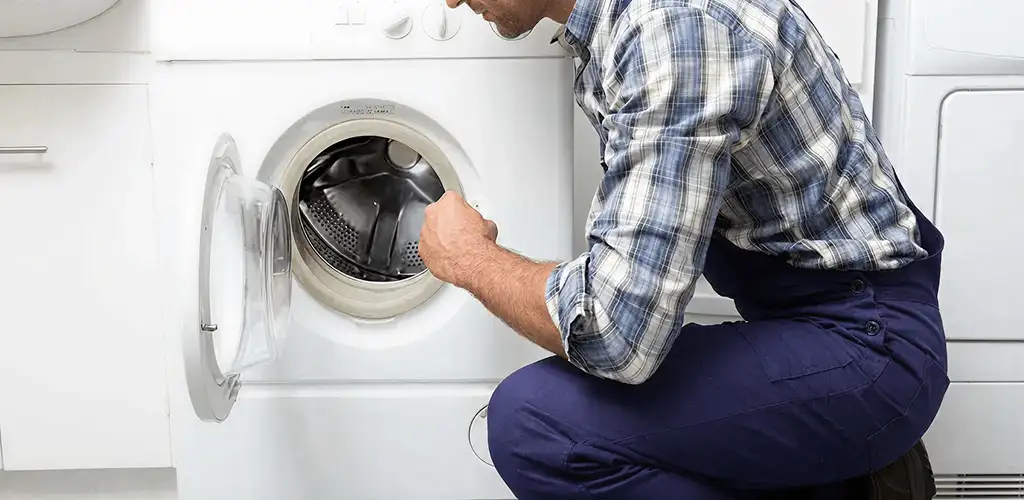 Handyman inspecting a dryer drum and internal parts for repair in Stockton, CA
