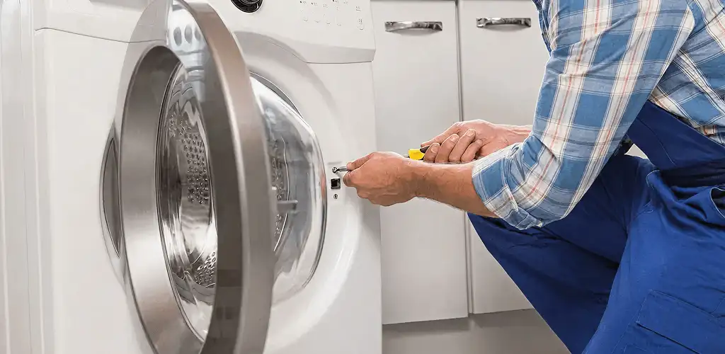 Handyman repairing a clothes dryer and checking electrical connections in Stockton, CA