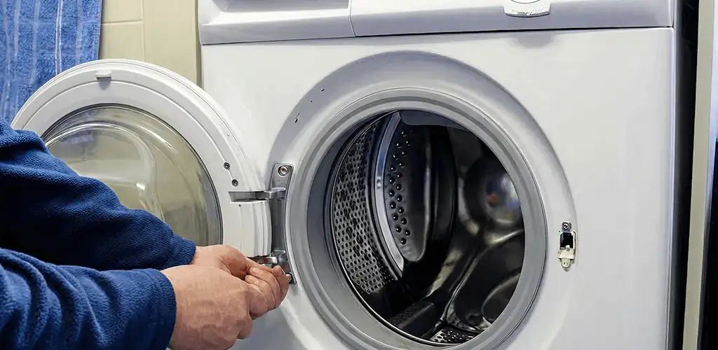 Washing machine repair handyman checking a front-load washer door and latch in Stockton, CA