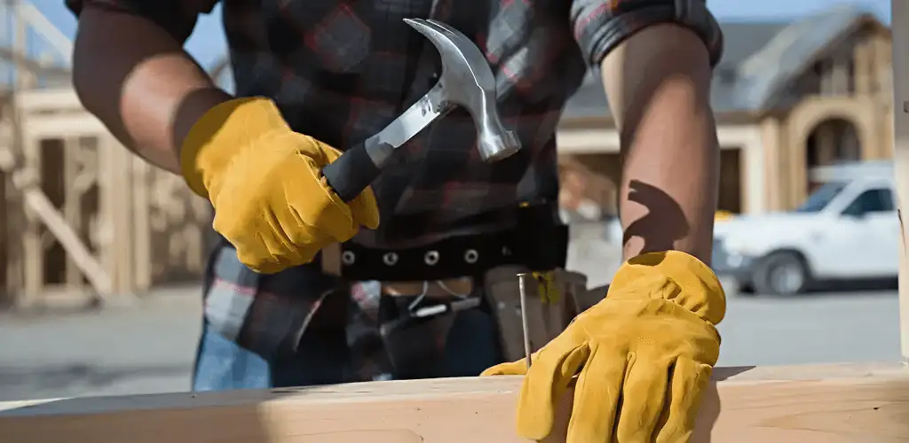 Handyman fixing wood trim with a hammer for home repairs in Stockton, CA