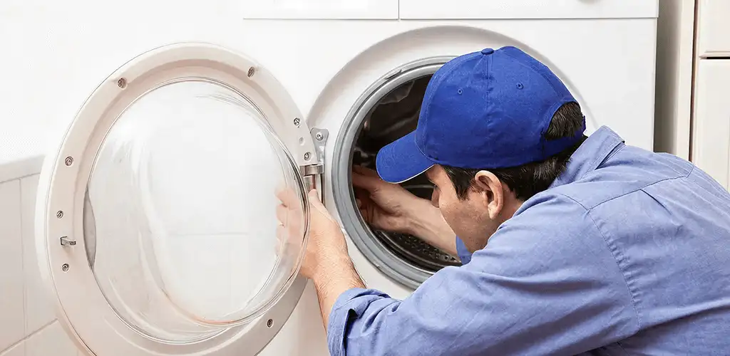 Washing machine repair handyman inspecting a front-load washer drum in Stockton, CA