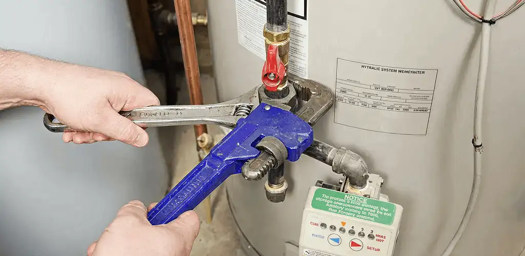Water heater repair technician tightening the shutoff valve and supply line in Stockton, CA